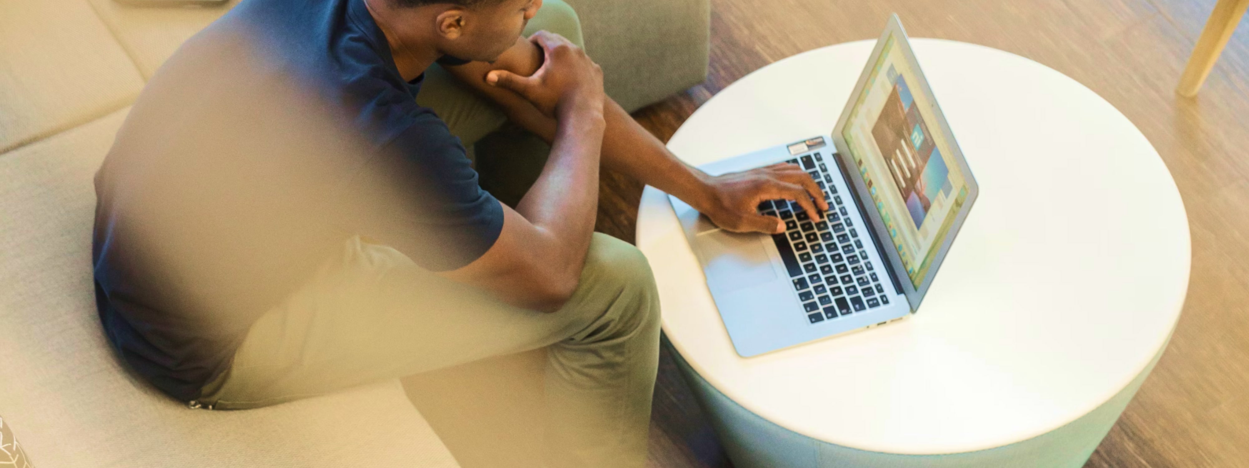 Person sitting at a round table working on a laptop